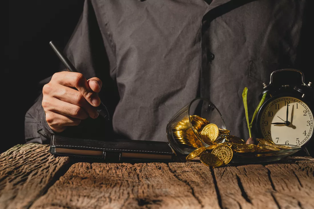 midsection-man-holding-book-while-standing-table